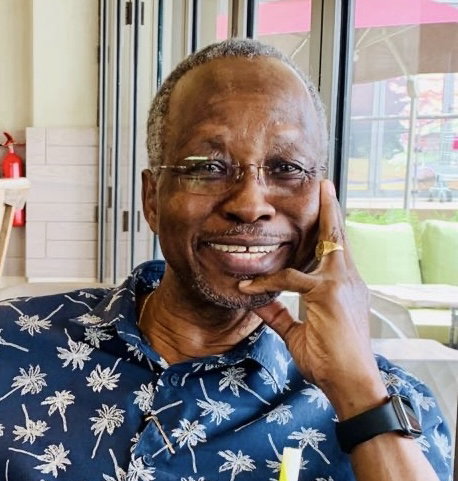 Prof. John Adwok smiling in a relaxed setting